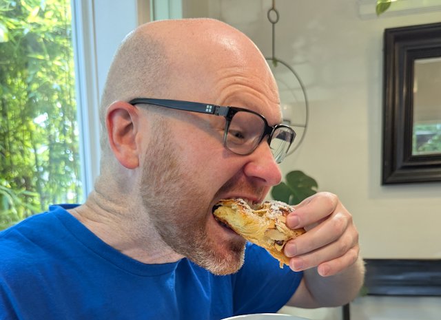Josh takes a bite of a croissant