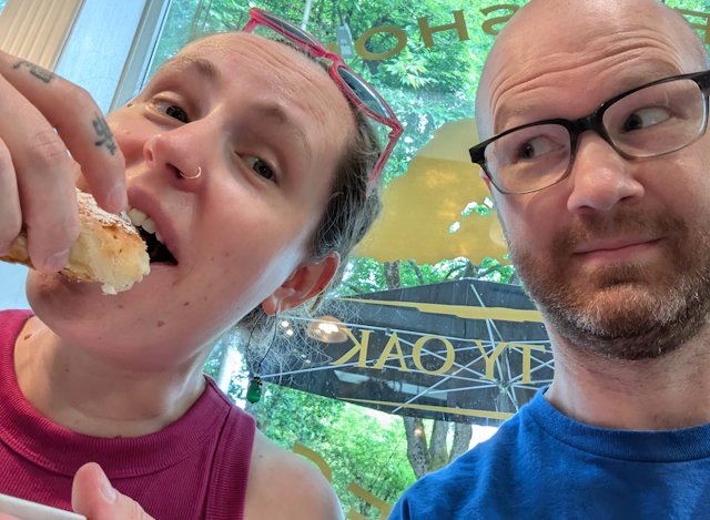 Stacey eats a pastry, while Josh makes selfie-face
