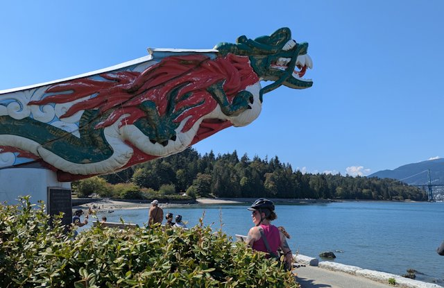 a painted piece of carved wood juts out over a view of the harbor
