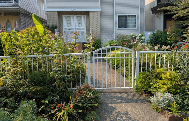 front garden with flowers and a white metal fence