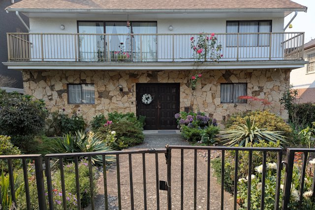 a two story house with stone work on the main floor