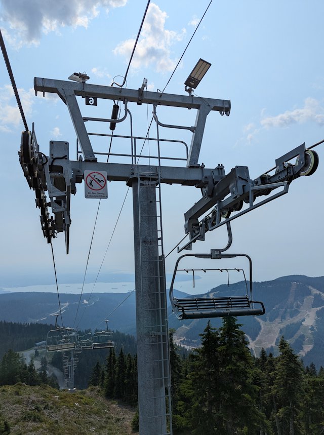 a pole supporting the ski lift with all the cables and pulleys