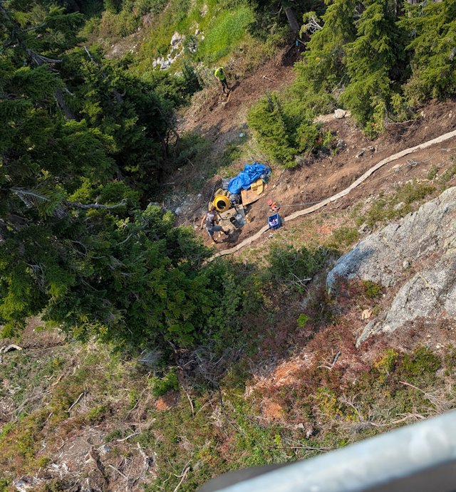 looking down from sky car on workers mixing concrete for a bike jump