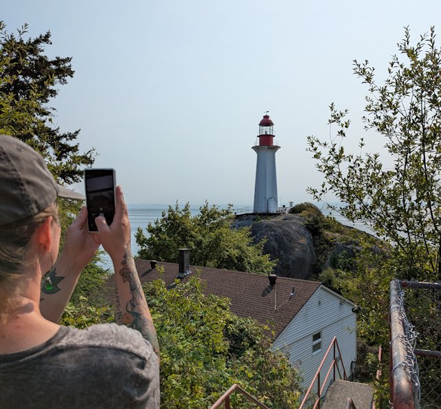 the lighthouse with Stacey in foreground also taking a picture of the lighthouse