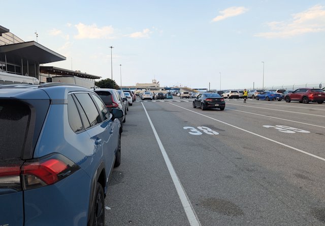 cars line up in lanes waiting to board the ferry