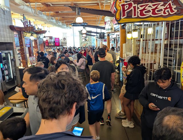 crowd of people in the ferry station lined with shops and resturants