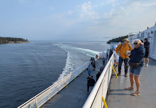 looking back from the the top deck there is a curved wake stretching out behind the ferry