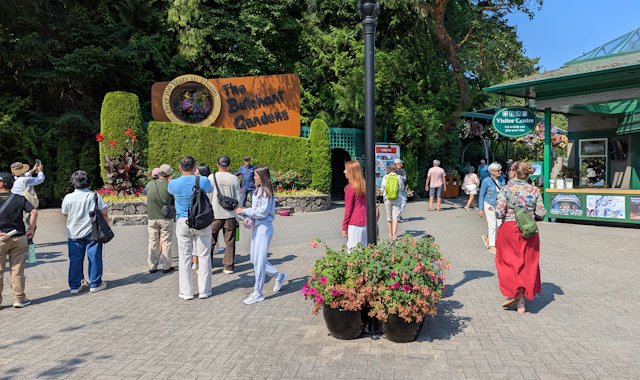 Main gardens sign and people around the Visitor Centre