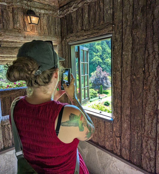 Stacey takes a picture out of a little wood house over the sunken gardens