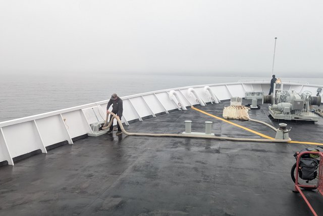 A crew member does something with the ropes