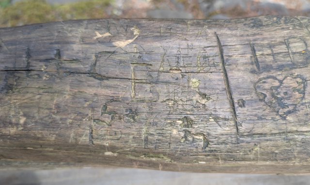 railing with initials and a heart carved into it